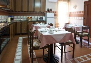 una cocina con 2 mesas con mantel rosa en Armonia B&B, en Trapani