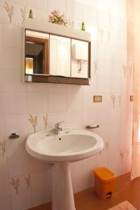 y baño con lavabo blanco y espejo. en Armonia B&B, en Trapani