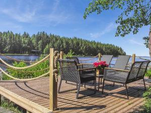 a wooden deck with chairs and a table with flowers at Holiday Home Sammonranta by Interhome in Kolinkylä
