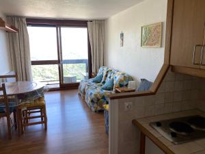 a living room with a couch and a table at Studio 22m² balcon Pégase Phenix Le Corbier in Le Corbier