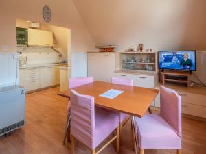 une cuisine et une salle à manger avec une table en bois et des chaises roses dans l'établissement Apartment Najade-2 by Interhome, à Lovran