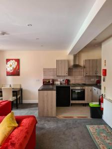 a kitchen with a red couch in a room at 3 Wood Yard Cottages, Red Mayes Farm in Long Sutton