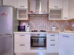 a kitchen with white cabinets and a stainless steel refrigerator at Apartment Adria by Interhome in Marčana