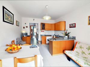 a kitchen and living room with a table and a couch at Apartment Terrazza Cala Rossa by Interhome in Nisporto