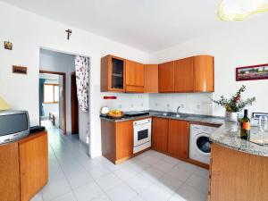 a kitchen with wooden cabinets and a dishwasher at Apartment Terrazza Cala Rossa by Interhome in Nisporto