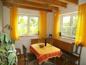 jadalnia ze stołem, krzesłami i oknami w obiekcie Ferienhaus Kettler I w mieście Muhr amSee
