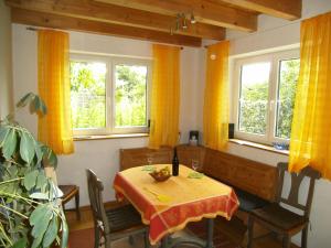 a dining room with a table and chairs and windows at Ferienhaus Kettler I in Muhr amSee