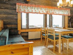 comedor con mesa, sillas y ventanas en Holiday Home Kulpakko 2 by Interhome, en Tiainen