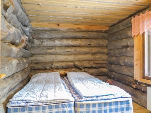 two beds in the corner of a log cabin at Holiday Home Kulpakko 2 by Interhome in Tiainen