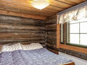 sypialnia z łóżkiem w drewnianym domku w obiekcie Holiday Home Kulpakko 3 by Interhome w mieście Tiainen