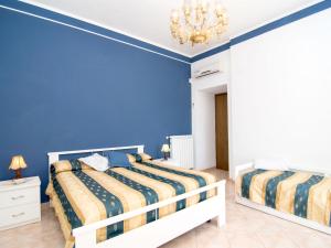 a blue bedroom with two beds and a chandelier at Holiday Home Emi by Interhome in Massa Lubrense