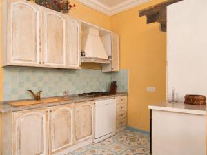 a kitchen with white cabinets and a sink at Holiday Home Emi by Interhome in Massa Lubrense