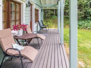 a porch with chairs and a table with flowers at Holiday Home Kuukatti by Interhome in Lahdenperä