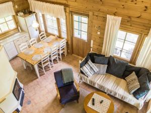 a living room with a couch and a table in a cabin at Holiday Home Kuukatti by Interhome in Lahdenperä