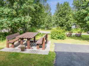 a picnic table and benches in a park at Holiday Home Kuukatti by Interhome in Lahdenperä