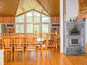 a dining room with a table and chairs and a fireplace at Holiday Home Saimaanhovi by Interhome in Hauhola