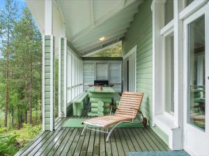 eine Veranda mit einem Stuhl und einem Tisch auf einem Haus in der Unterkunft Holiday Home Saimaanhovi by Interhome in Hauhola