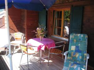 un tavolo e sedie sul portico di una cabina di Apartment Lischenhaus - Strubel by Interhome a Lenk