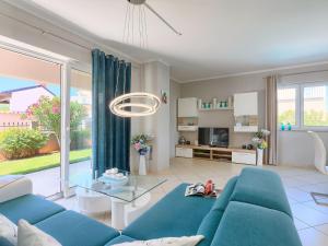 a living room with a blue couch and a glass table at Holiday Home Villa Valentina by Interhome in Loborika