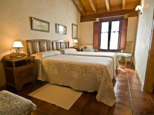 a bedroom with two beds and a table and a window at Casa Rural El Meson in Briones