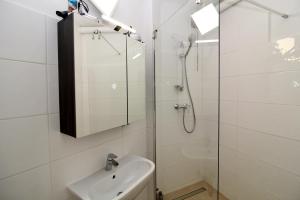 biała łazienka z prysznicem i umywalką w obiekcie Balcony Apartment - Next to Opera w Wiedniu +23 zdjęcia