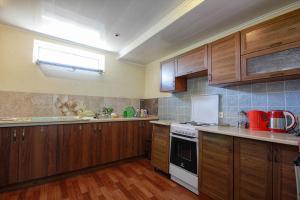 a kitchen with wooden cabinets and a white stove top oven at Одеська,8 in Chornomorsk