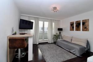 ein Wohnzimmer mit einem Sofa und einem TV in der Unterkunft Balcony Apartment - Next to Opera in Wien
