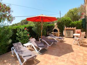 grupa krzeseł i parasol na patio w obiekcie Holiday Home Schnuffi by Interhome w Porto Cristo