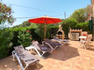 a group of chairs and an umbrella on a patio at Holiday Home Schnuffi - PCN155 by Interhome in Porto Cristo