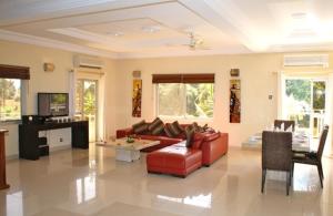 a living room with a red couch and a table at WaveCrest Luxury Boutique Apartments in Kotu