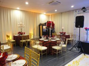 a dining room with tables and chairs and a stage at Druds Hotel Hortolândia in Hortolândia