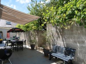 een patio met een tafel en stoelen en een bank bij Holiday Home Pors Ar Goff - PNG102 by Interhome in Plouégat-Guérand
