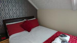 sypialnia z łóżkiem z białymi i czerwonymi poduszkami w obiekcie Ash Lea Hotel w Blackpool