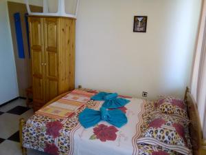 a bedroom with a bed with blue bows on it at Семеен хотел Бостън in Ravda +32 photos