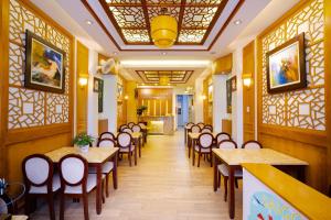 Saigon Amigo Hotel في مدينة هوشي منه: غرفة طعام مع طاولات وكراسي في مطعم