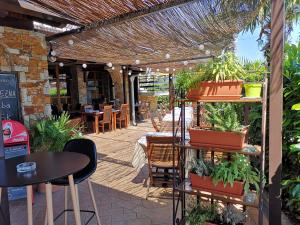 um pátio com uma mesa, cadeiras e vasos de plantas em Hotel Bio em Koper