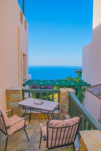 a patio with a table and chairs and the ocean at Althea Archontika Tis Androu in Batsi