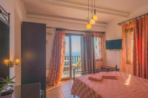 a bedroom with a bed and a view of the ocean at Althea Archontika Tis Androu in Batsi