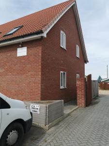 a red brick house with a sign on it at 3 Wood Yard Cottages, Red Mayes Farm in Long Sutton