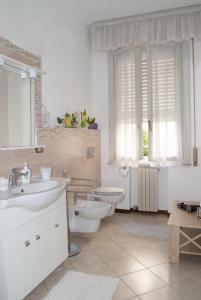 a bathroom with two sinks and a toilet and a window at La Casa di Tino in Fontanellato +26 photos