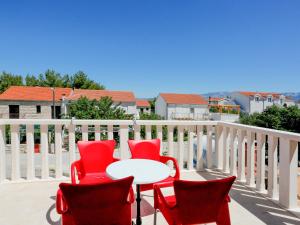 patio z czerwonymi krzesłami i stołem na balkonie w obiekcie Holiday Home Gorana - BRC152 by Interhome w mieście Mirce