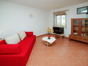 salon z czerwoną kanapą i telewizorem w obiekcie Holiday Home Gorana - BRC152 by Interhome w mieście Mirce