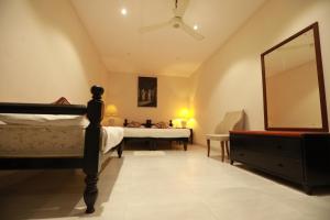 a bedroom with a bed and a mirror and a dresser at Earl's Red Kurunegala in Kurunegala