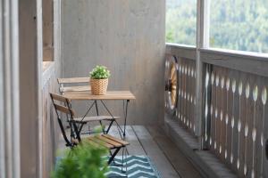 a table and chair on a porch with a potted plant at Erlebnisbauernhof Gutschi Ranch in Kamp