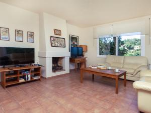 a living room with a couch and a tv at Holiday Home Xarmada Cecilia by Interhome in Begur