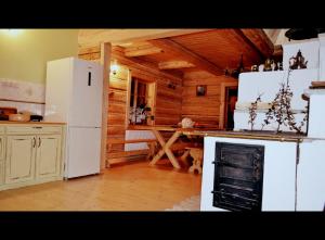 a kitchen with a white refrigerator and a stove at Dom Gościnny Szpilkowo in Nowica +21 photos
