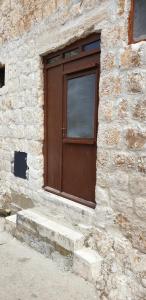 a stone building with a wooden door and stairs at Apartmani Sole in Vis