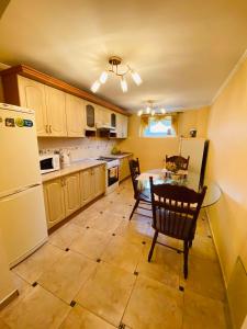 uma cozinha com uma mesa e um frigorífico branco em Grand Apartment em Nelipyno