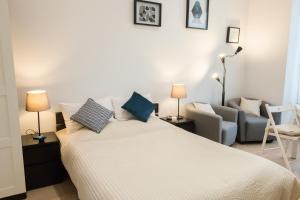 een slaapkamer met een wit bed en een bank bij Le Gérémoy in Vittel
