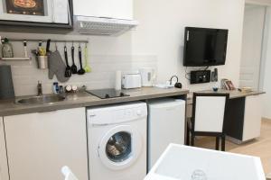 a kitchen with a washing machine and a sink at Le Gérémoy in Vittel